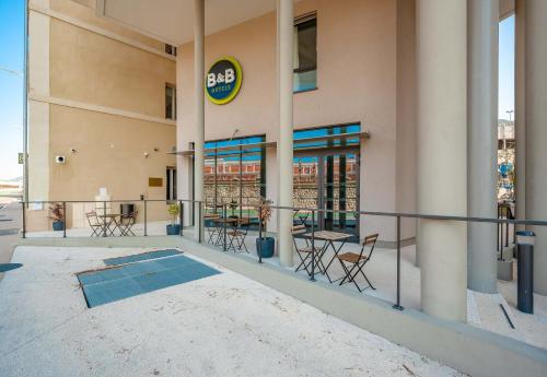 a building with chairs and tables outside of it at B&B HOTEL Toulon Centre Gare in Toulon