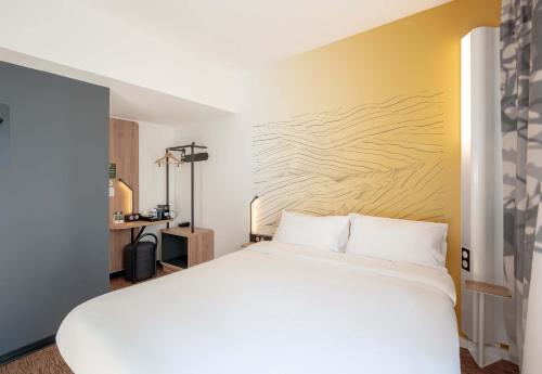 a bedroom with a white bed and a yellow wall at B&B HOTEL Toulon Centre Gare in Toulon