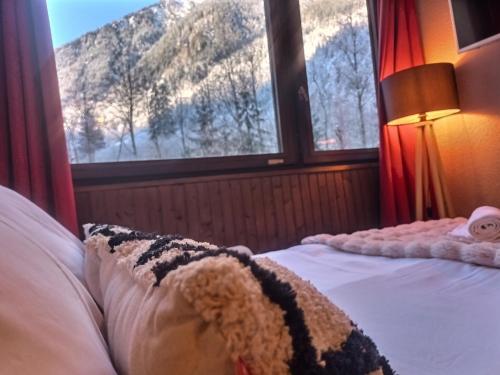 - une chambre avec un lit et une vue sur la montagne dans l'établissement Chamonix : Studio intime au bord du lac des Gaillands et pistes de ski, à Chamonix-Mont-Blanc