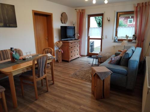 a living room with a blue couch and a table at Ferienwohnung Fahrner in Baiersbronn