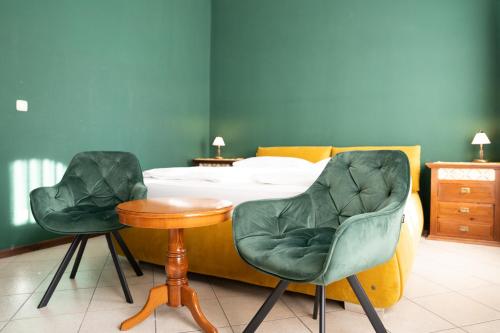 two chairs and a table in a bedroom with a bed at Hotel Urania in Vienna
