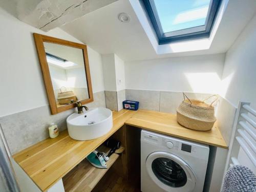 une salle de bain avec un lavabo et une machine à laver dans l'établissement Le Templiers avec Terrasse - Hyper Centre Lr, à La Rochelle
