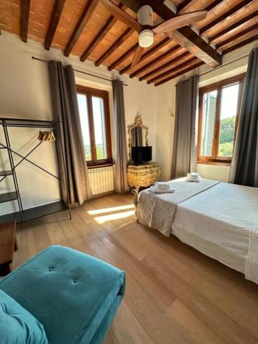 a bedroom with a large bed in a room with windows at Villa La Gioconda Rooms in Arezzo
