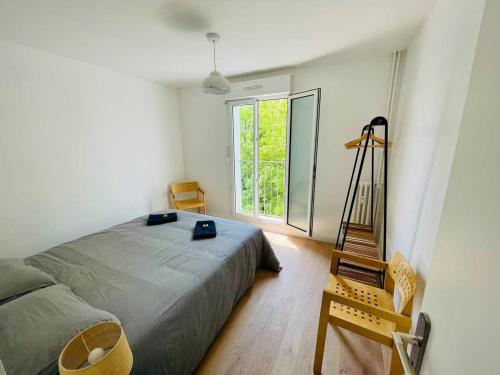 une chambre avec un lit et une grande fenêtre dans l'établissement Le Cordeliers Confort - Parking Wifi, à La Rochelle