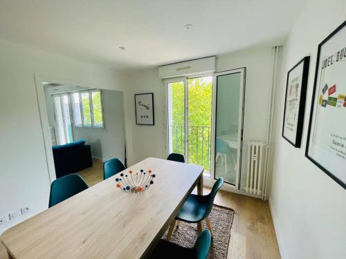 une salle à manger avec une table et des chaises en bois dans l'établissement Le Cordeliers Confort - Parking Wifi, à La Rochelle