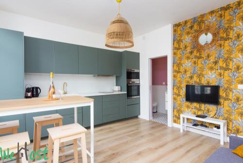 Il comprend une cuisine avec des placards bleus et une télévision murale. dans l'établissement Appartement Contemporain Centre ville et Plages, à Nice