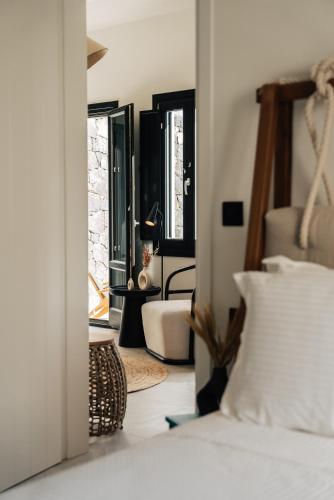 a bedroom with a bed and a room with a mirror at Erthā Suites with private pools in Vóthon