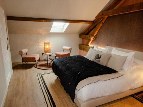 a bedroom with a large bed and a skylight at La Longère de Bourgogne in Demigny