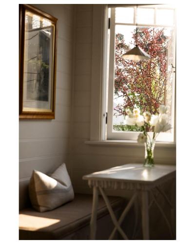 a vase of flowers on a table next to a window at The Potting Shed at Bunya House in Bowral