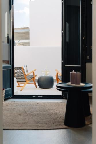 a living room with a table and a chair at Erthā Suites with private pools in Vóthon