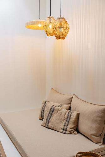 a room with a couch with two lights and two pillows at Erthā Suites with private pools in Vóthon