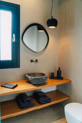 a bathroom with a sink and a mirror at Erthā Suites with private pools in Vóthon
