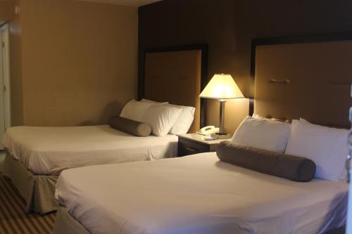 a hotel room with two beds and a lamp at Travelodge by Wyndham Bellmawr in Bellmawr