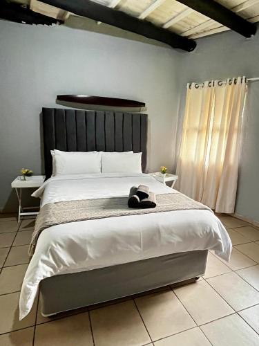 a bed with a pair of shoes sitting on it at Indlovu Inn Guesthouse in Graskop
