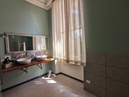 a bathroom with two sinks and a mirror at Tenuta San Giorgio in Serravalle Scrivia