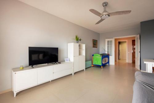 a living room with a flat screen tv on a white cabinet at Winahost Valencia El Puig 1 in El Puig