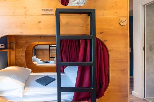 a bunk bed with a ladder in a room at Privatisation Hostel in Faverges