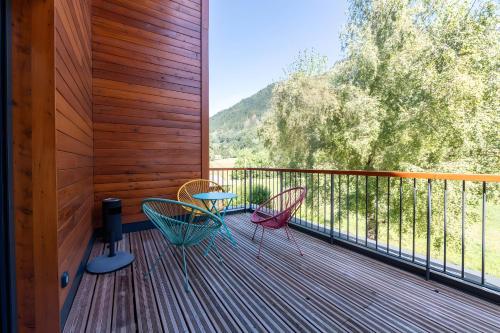 a deck with two chairs and a table on it at Privatisation Hostel in Faverges