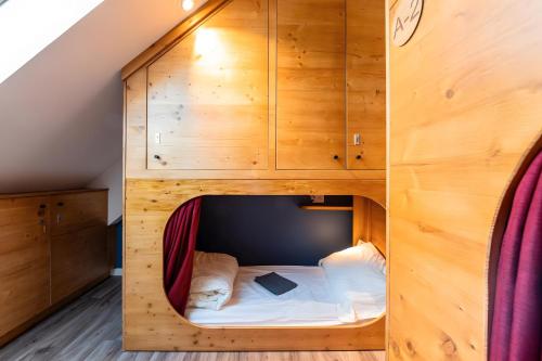 a bed in a wooden cabin in a room at Privatisation Hostel in Faverges