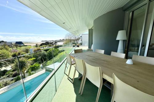 une salle à manger avec une table et une vue sur l'océan dans l'établissement Luxury ! Villa d’architecte piscine - Vue mer 180, à Guidel