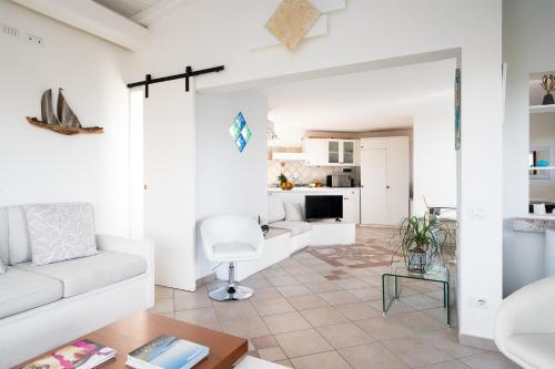 Una sala de estar con un sofá blanco y una mesa. en Villa Aurazure by Klodge, en Olbia