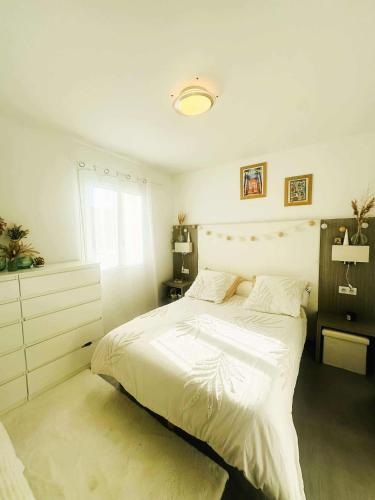 une chambre avec un lit blanc et une fenêtre dans l'établissement Bel appartement proche de la mer, à Monticello