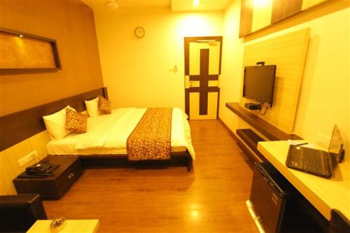 a hotel room with a bed and a television at Hotel Princess in Ankleshwar