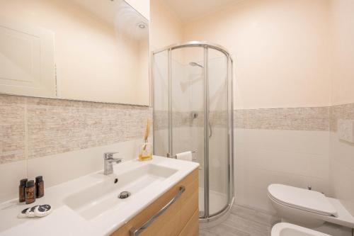 Un baño con lavabo, inodoro y ducha. en Moderne Maison Ariston, en San Remo