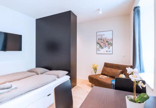 a living room with a bed and a couch at HITrental Central Station Apartment in Zürich