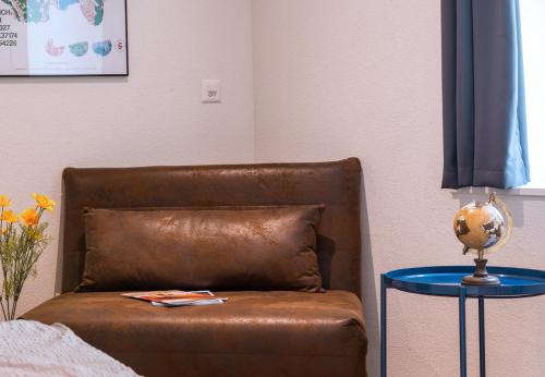 a brown leather chair sitting next to a table at HITrental Central Station Apartment in Zürich