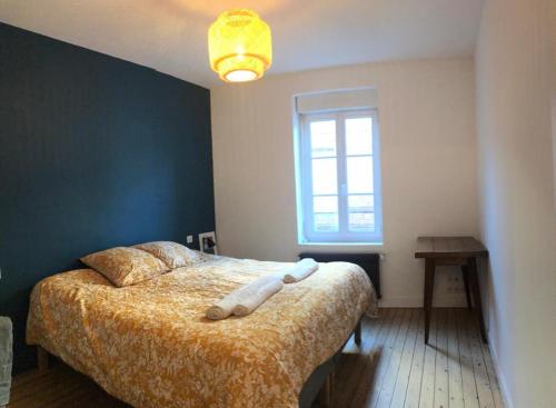 - une chambre avec un lit doté d'une couverture jaune et d'une fenêtre dans l'établissement La Louisette, à Fécamp