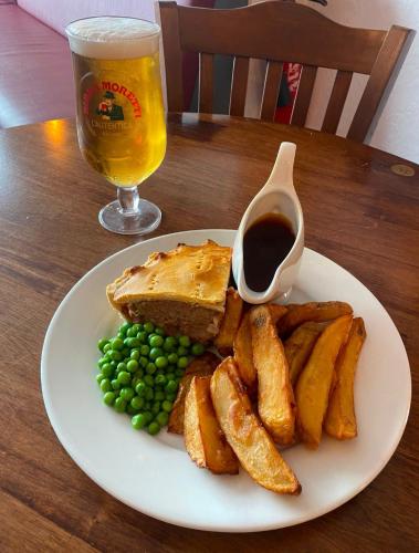 a plate with a sandwich and peas and a glass of beer at The Station Hotel in Billingham