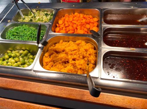 a buffet with several trays of food and vegetables at The Station Hotel in Billingham