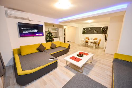 a living room with a yellow couch and a table at Bucharest Accommodation Apartments in Bucharest