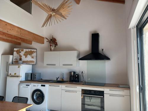 Il comprend une cuisine équipée d'une cuisinière et d'un lave-linge/sèche-linge. dans l'établissement Jolie maison à Biscarrosse zéro six soixante treize soixante huit vingt six 02, à Biscarrosse