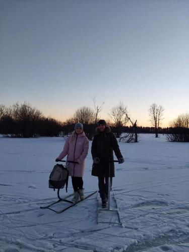 two people walking through the snow on skis at Soomaa Puhkeküla in Riisa