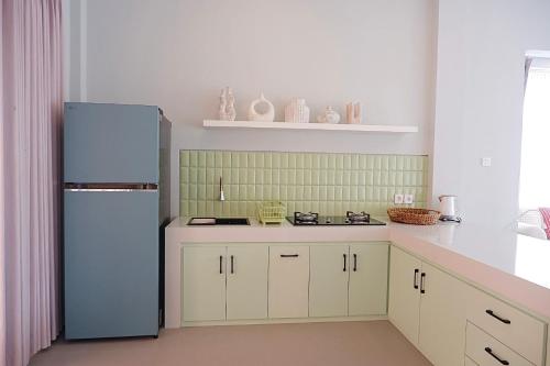 a kitchen with white cabinets and a refrigerator at Ponder Bali Canggu in Canggu