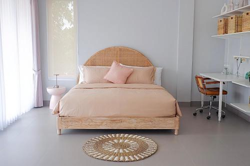 a bedroom with a large bed and a desk at Ponder Bali Canggu in Canggu