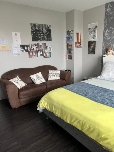 a bedroom with a bed and a couch in it at Le Clos Louisiane in Saint-Loup-Hors