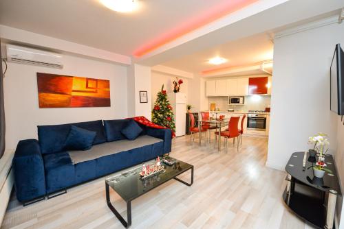 a living room with a blue couch and a christmas tree at Bucharest Accommodation Apartments in Bucharest
