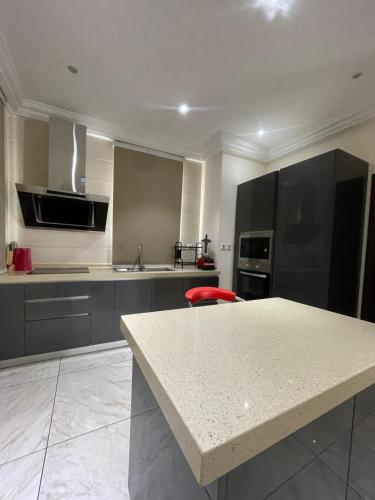 a kitchen with a counter and a red chair in it at Amazing Duplex Suite Available in Accra