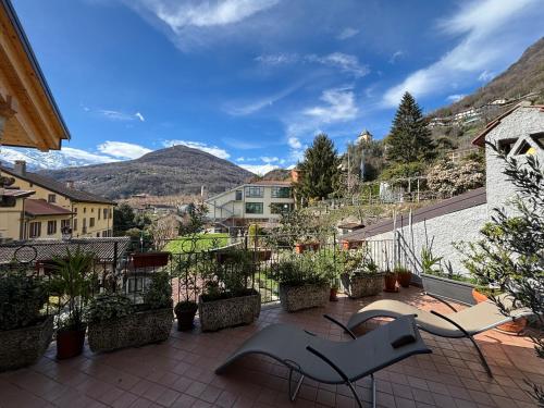 a balcony with chairs and a view of a city at Breva e Tivano - Larihome A54 in Gravedona