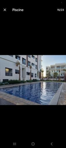 a picture of a swimming pool in front of a building at Appartement Moderne et Confortable in Bouznika
