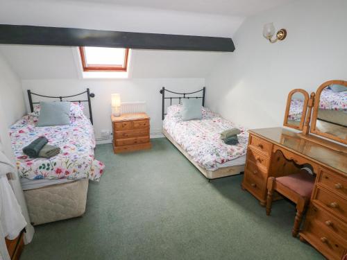 1 Schlafzimmer mit 2 Einzelbetten und einer Kommode in der Unterkunft Barn Cottage in Spittal