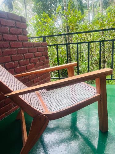 a wooden bench sitting on top of a balcony at MUM Jungle Inn in Ella