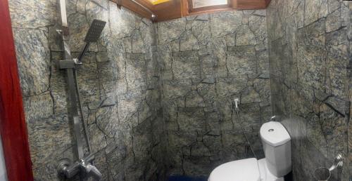 a bathroom with a stone shower with a toilet at MUM Jungle Inn in Ella