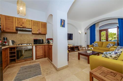 a kitchen and a living room with a couch and a table at Style Apartment in nubian design at lagoon in Hurghada