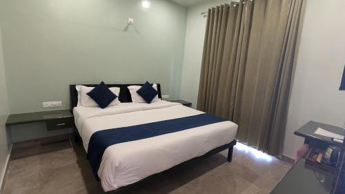 a bedroom with a large bed with blue pillows at MAHA RAAS A unit of RAAS LEELA Hotels and Resort in Udaipur