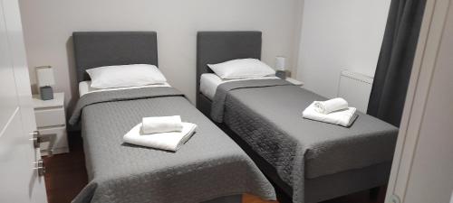 two twin beds in a room with towels on them at Apartmani METRO in Loznica