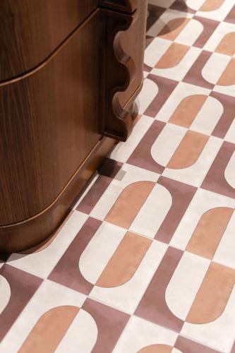 a brown and white checkered floor with a wooden door at 1.75 Paris La Trêve in Paris